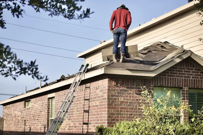 Professional roofer working on a residential roof in Holly